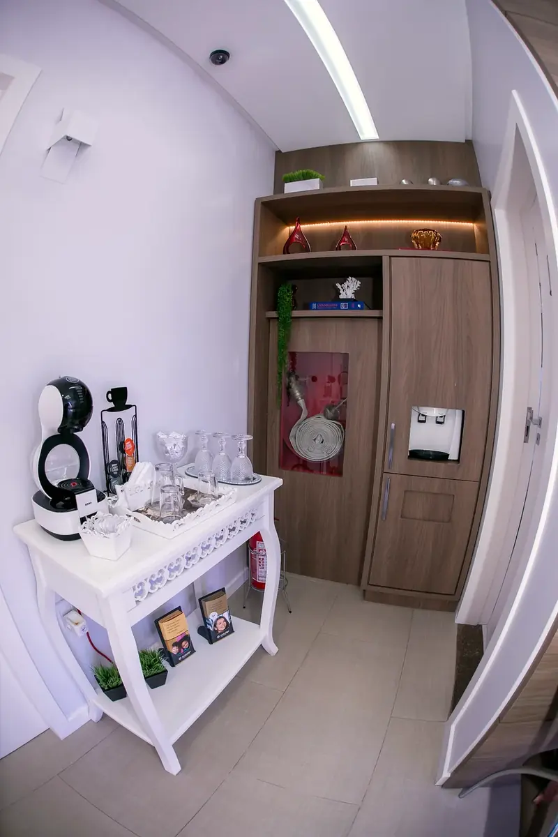 Corredor com cafeteira e estante branca